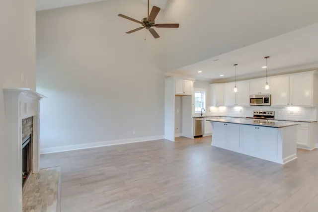 a view of kitchen with stainless steel appliances refrigerator stove microwave and cabinets
