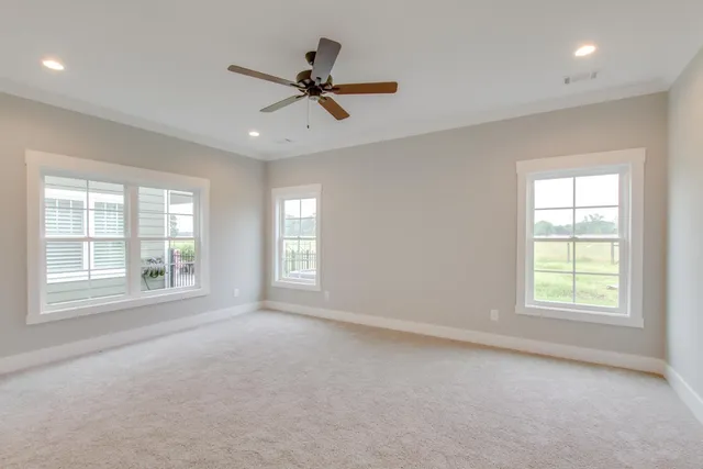 an empty room with windows and fan