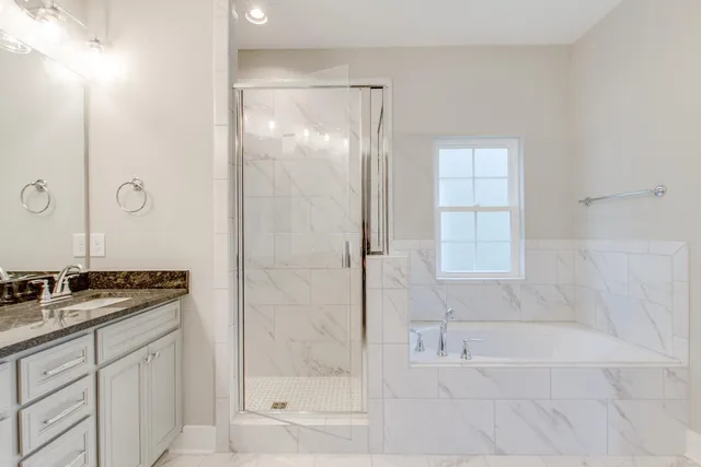a bathroom with a granite countertop sink a mirror and a bathtub