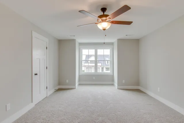 an empty room with fan and windows