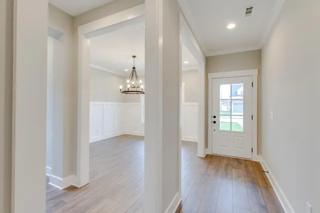 an empty room with wooden floor & windows