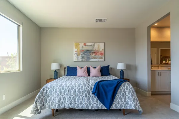 a bedroom with a bed and painting on the wall