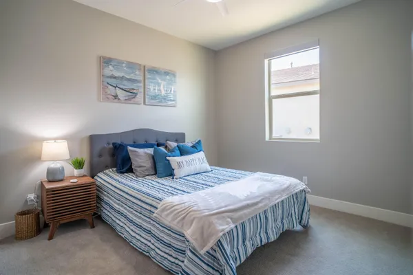 a bedroom with a bed a lamp and a window