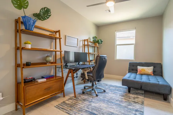 a view of a workspace with furniture and a window