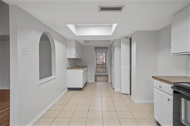a view of a kitchen with windows and cabinet