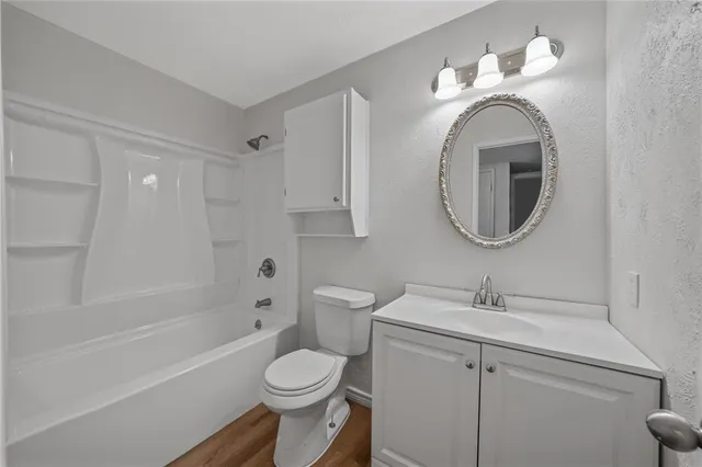 a bathroom with a toilet sink a mirror and bathtub