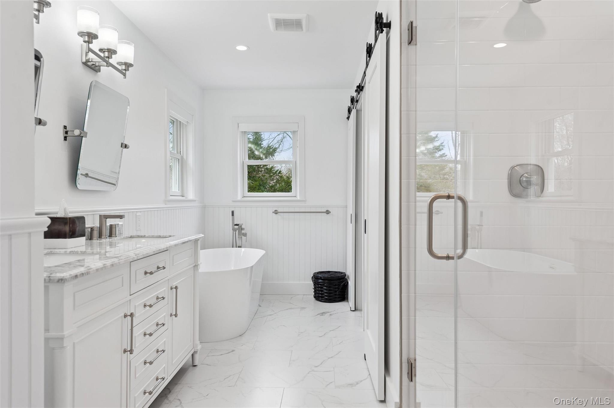 4056 Noyack Road Sag Harbor, NY 11963 - Photo 12 of 21 a bathroom with a double vanity sink toilet mirror and shower
