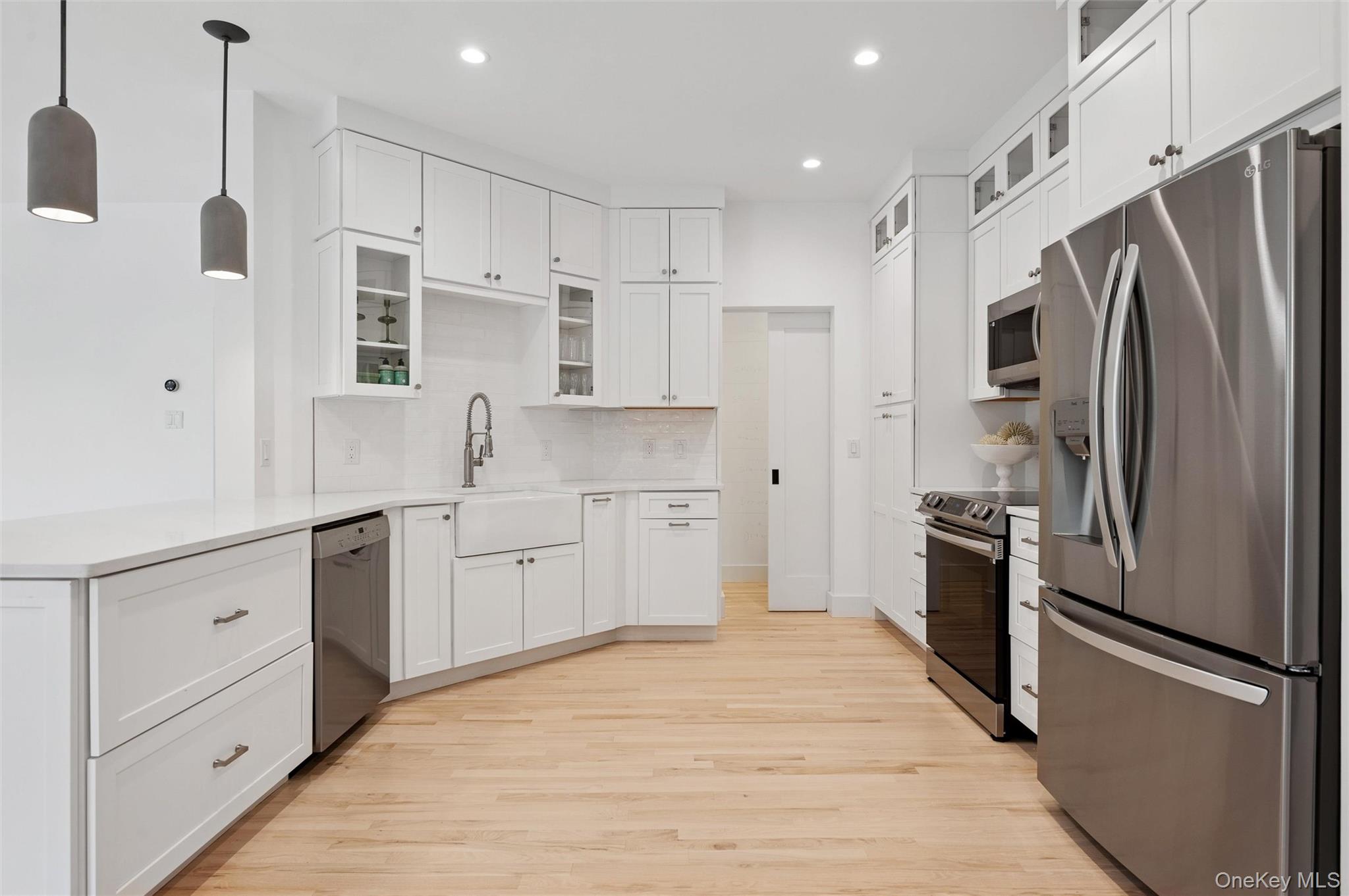 4056 Noyack Road Sag Harbor, NY 11963 - Photo 9 of 21 a kitchen with stainless steel appliances a refrigerator sink and cabinets