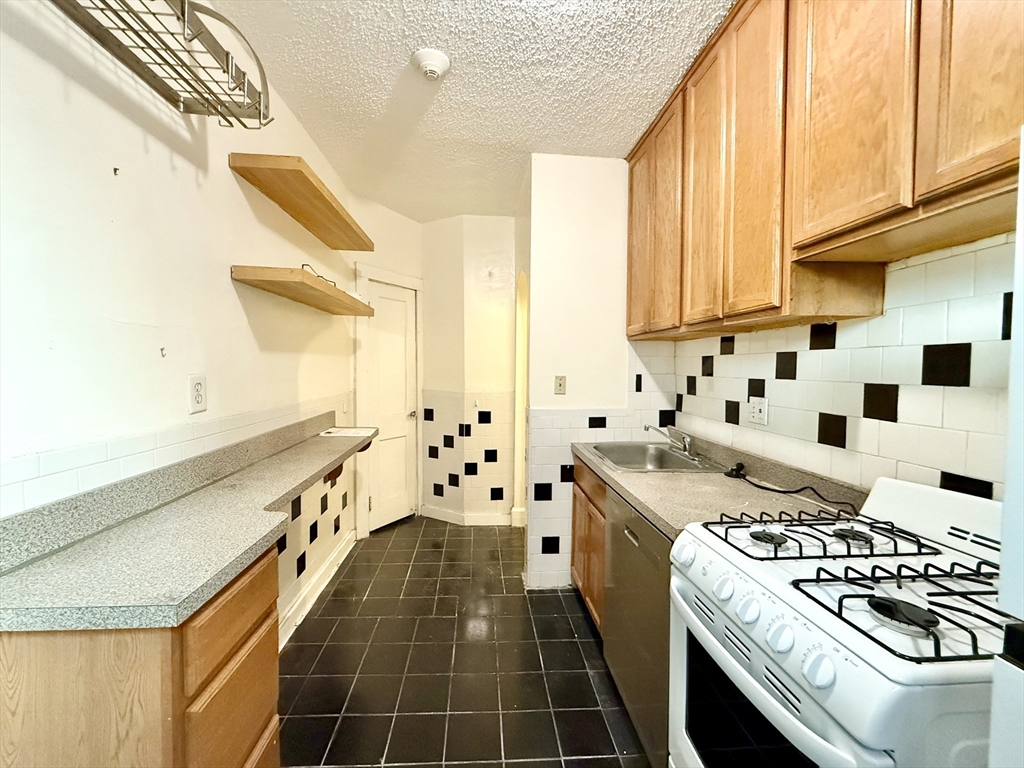 26 Chiswick Road, Unit 6 Boston, MA 02135 - Photo 3 of 19 a kitchen with stainless steel appliances a stove a sink and a refrigerator