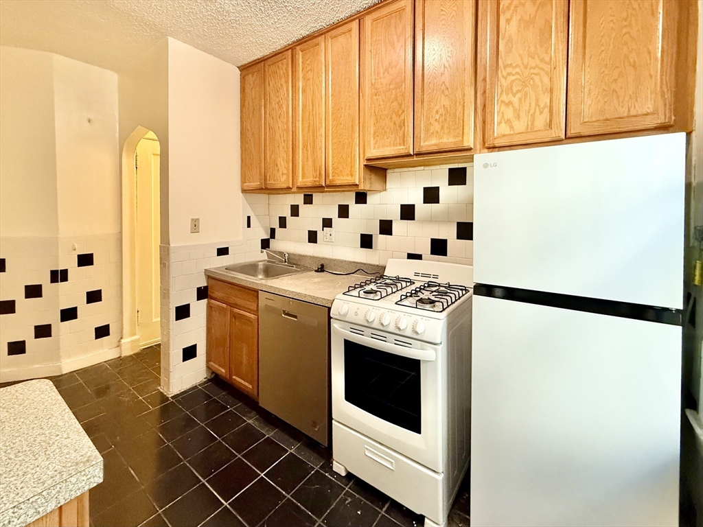 26 Chiswick Road, Unit 6 Boston, MA 02135 - Photo 5 of 19 a kitchen with stainless steel appliances a stove a sink and a refrigerator