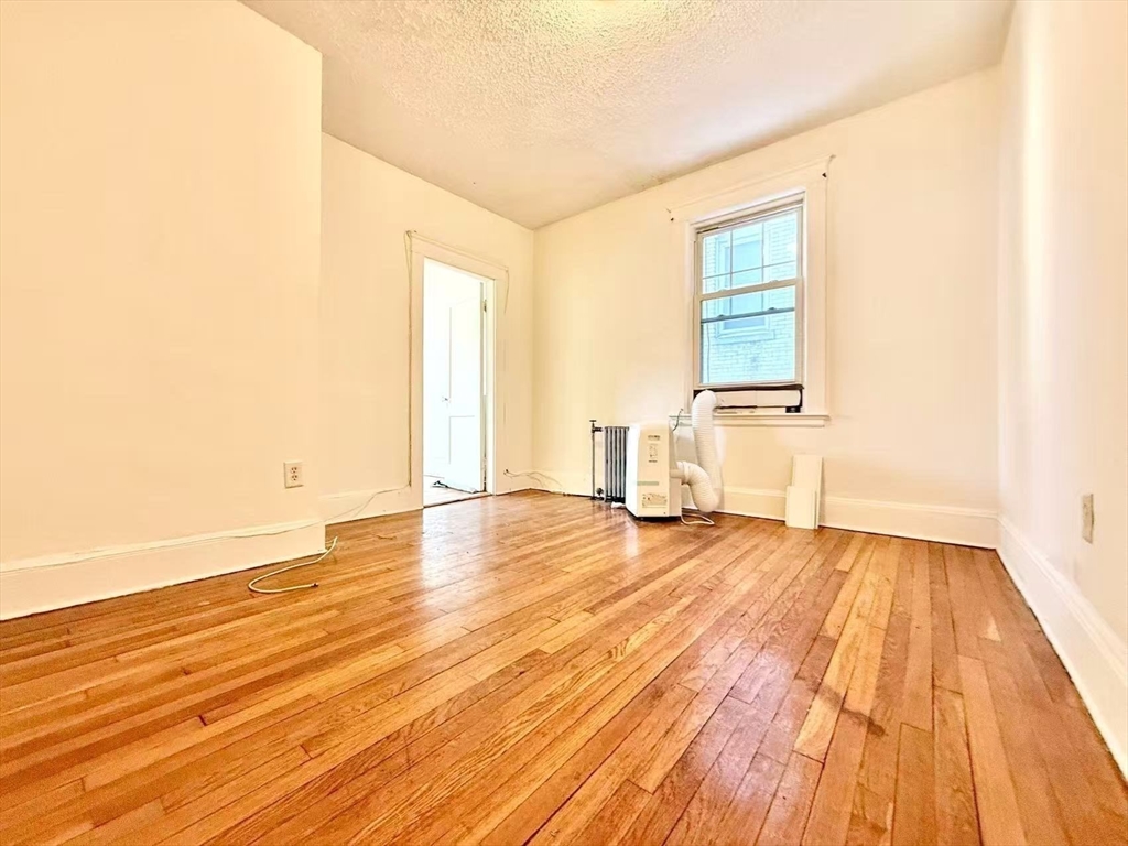 26 Chiswick Road, Unit 6 Boston, MA 02135 - Photo 8 of 19 a view of empty room with wooden floor and fan