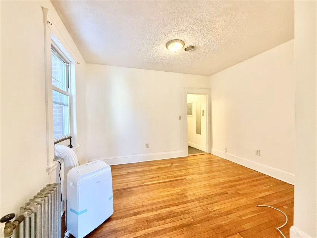 26 Chiswick Road, Unit 6 Boston, MA 02135 - Photo 10 of 19 a bedroom with a bed and wooden floor
