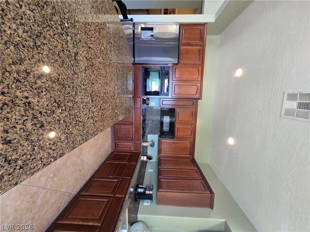 2567 Dirleton Place Henderson, NV 89044 - Photo 13 of 67 A gourmet kitchen boasts premium stainless steel appliances and abundant granite counter space for culinary endeavors.