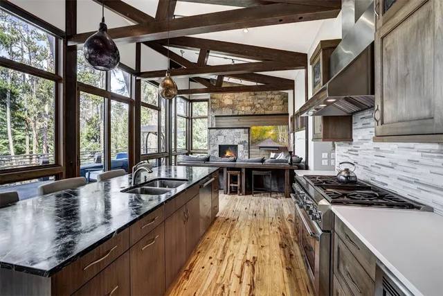 a kitchen with stainless steel appliances granite countertop a stove and a wooden floors