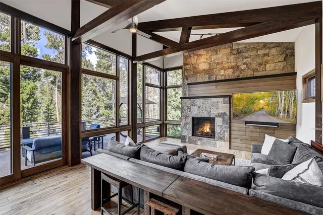a living room with furniture a table and large windows