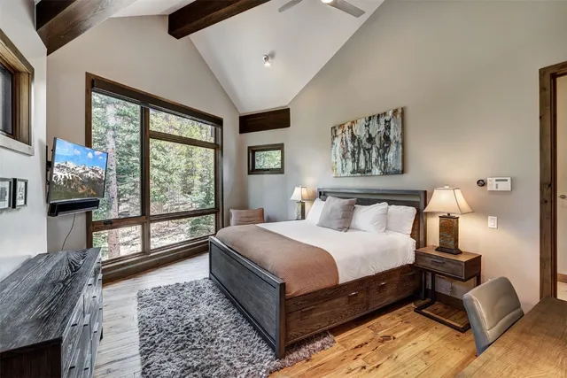 a bedroom with a large bed a potted plant and dresser