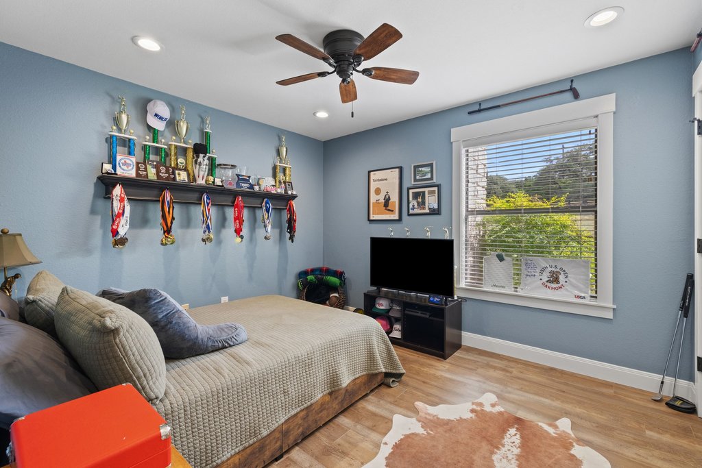 23644 Nameless Road Leander, TX 78641 - Photo 12 of 40 Warm wood-look flooring and recessed lighting illuminate this restful bedroom retreat.