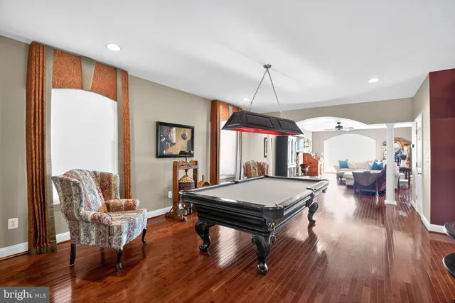 a living room with lots of furniture kitchen view and a chandelier