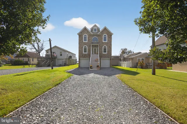 a view of a big house with a big yard and large trees