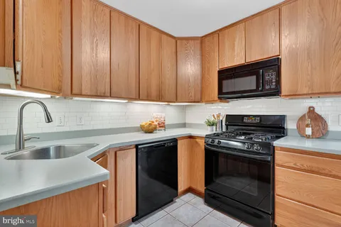 a kitchen with granite countertop wooden cabinets a stove top oven and granite countertops