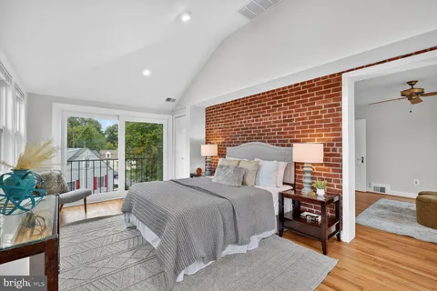 a bedroom with a bed a table and a potted plant