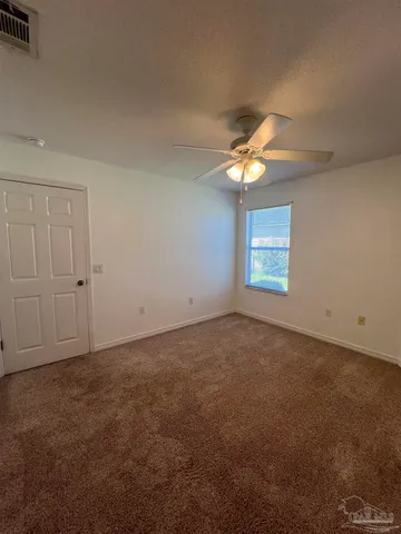 an empty room with a window and a fan
