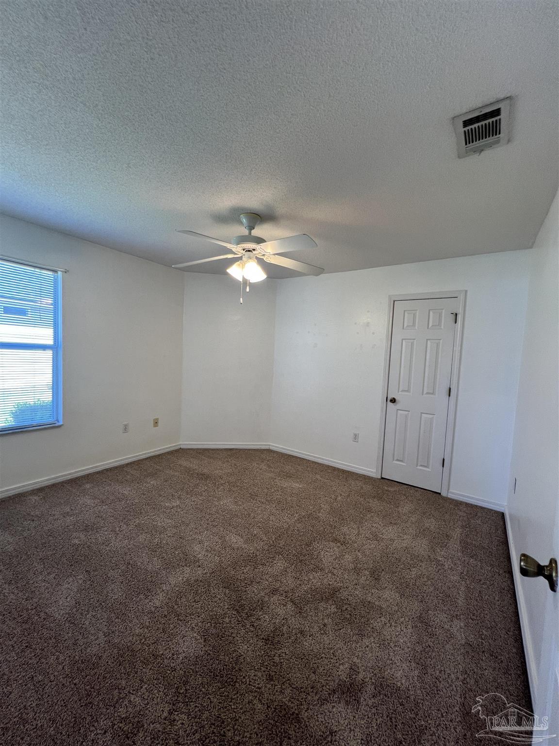 120 Nivana Drive Crestview, FL 32536 - Photo 12 of 20 an empty room with a chandelier fan and windows