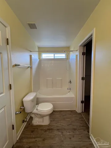 a bathroom with a toilet and a bath tub