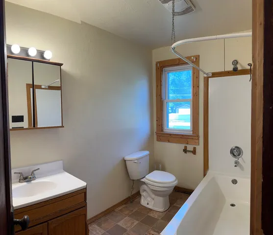 a bathroom with a toilet sink and mirror