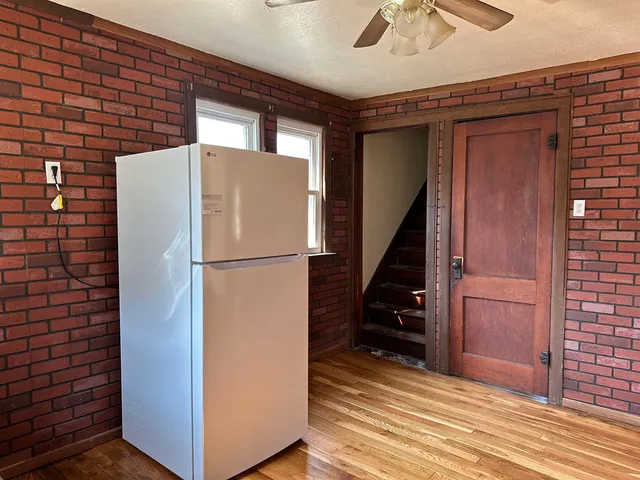 a view of a hallway with wooden floor and staircase