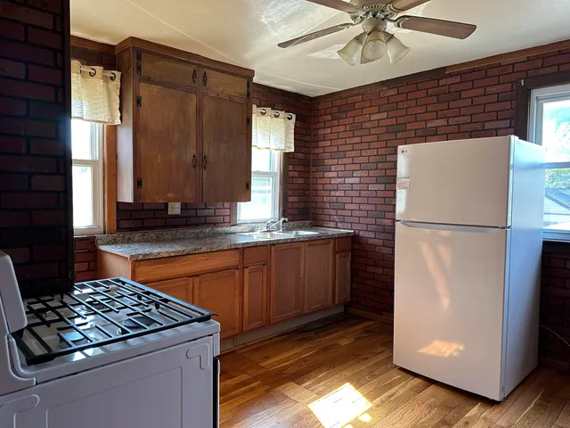 a kitchen with stainless steel appliances granite countertop a refrigerator a sink and a stove