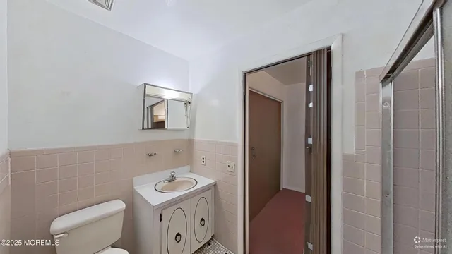 a bathroom with a toilet a sink and mirror