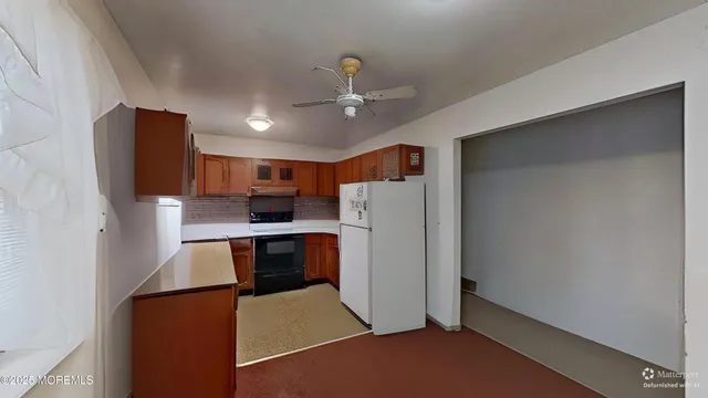 a open kitchen with stainless steel appliances a refrigerator and a stove top oven