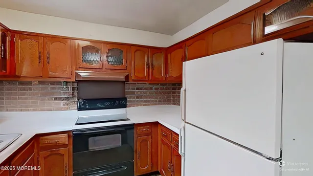 a kitchen with stainless steel appliances granite countertop a refrigerator and a stove top oven
