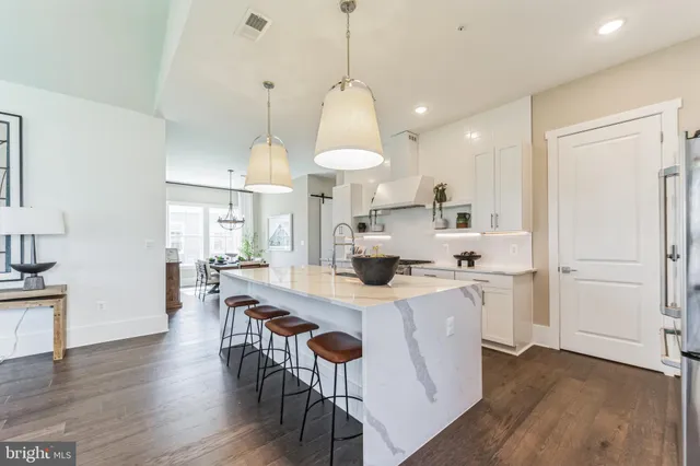 a kitchen with stainless steel appliances kitchen island a island in the center and wooden floors