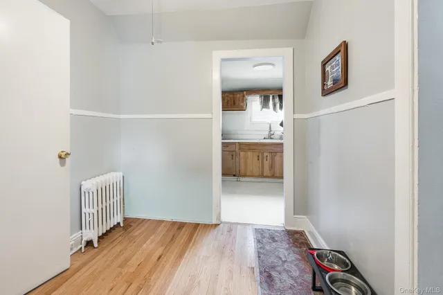 a view of hallway with bathroom and wooden floor