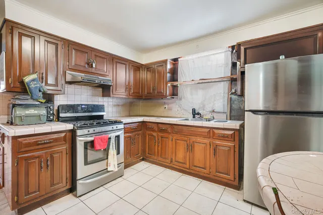 a kitchen with stainless steel appliances granite countertop a refrigerator sink and stove