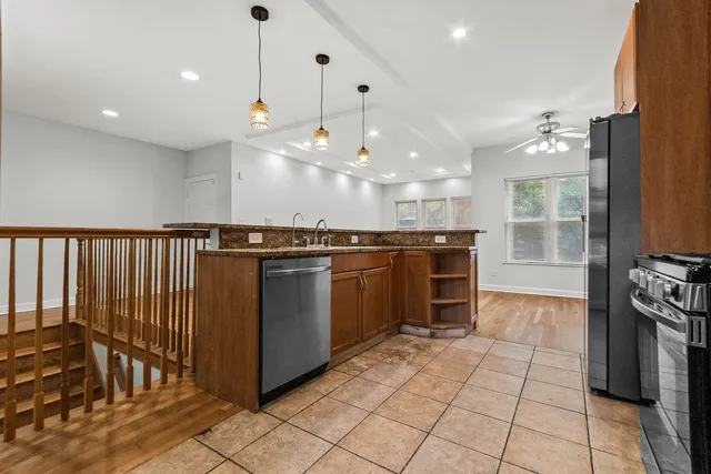 a kitchen with stainless steel appliances granite countertop a stove a sink and a refrigerator