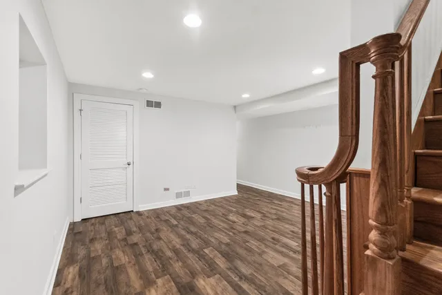 a view of a hallway with wooden floor and staircase