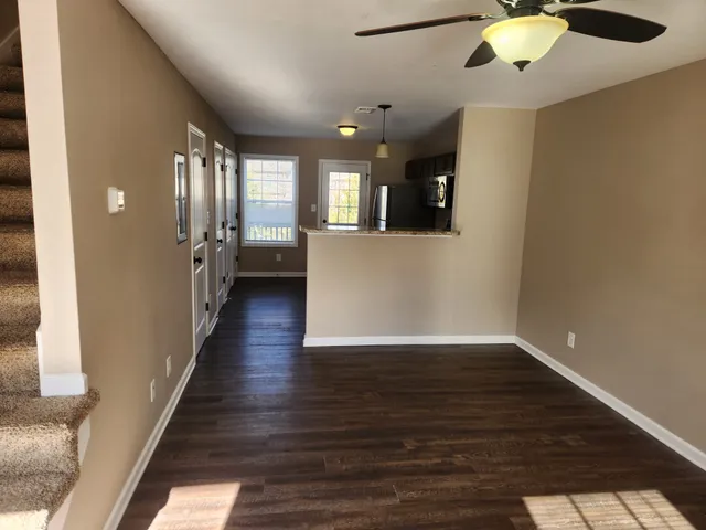 a view of a hallway with wooden floor and staircase