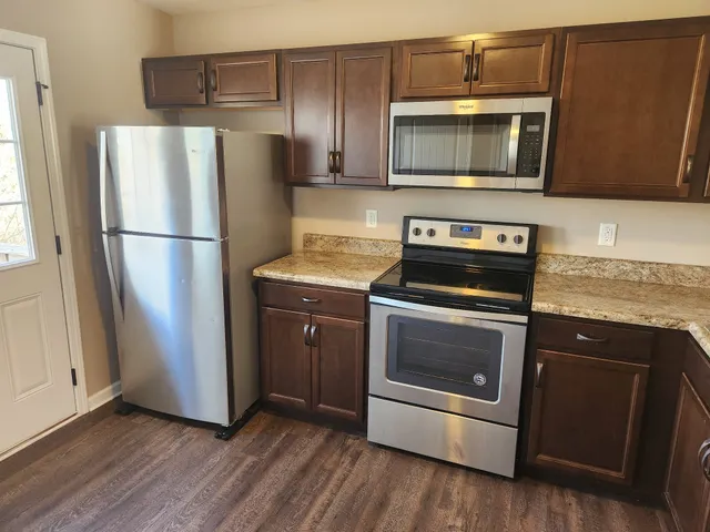 a kitchen with granite countertop stainless steel appliances and wooden cabinets