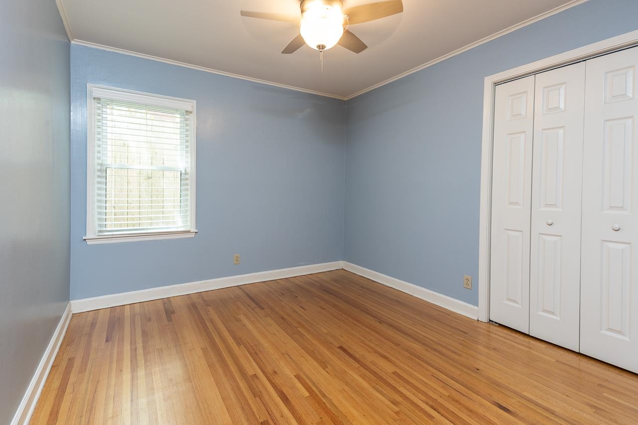 4696 Kaye Road Memphis, TN 38117 - Photo 12 of 39 a view of an empty room with wooden floor and a window