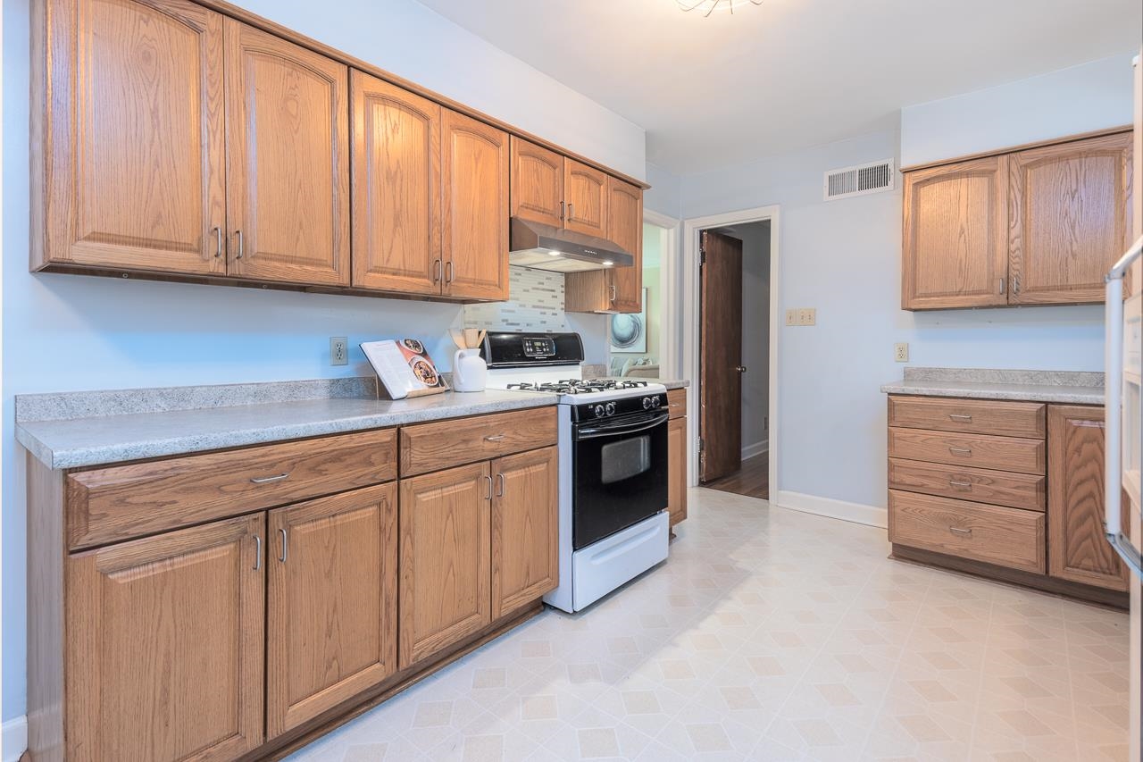 4696 Kaye Road Memphis, TN 38117 - Photo 22 of 39 a kitchen with stainless steel appliances granite countertop a stove a sink and a refrigerator with cabinets