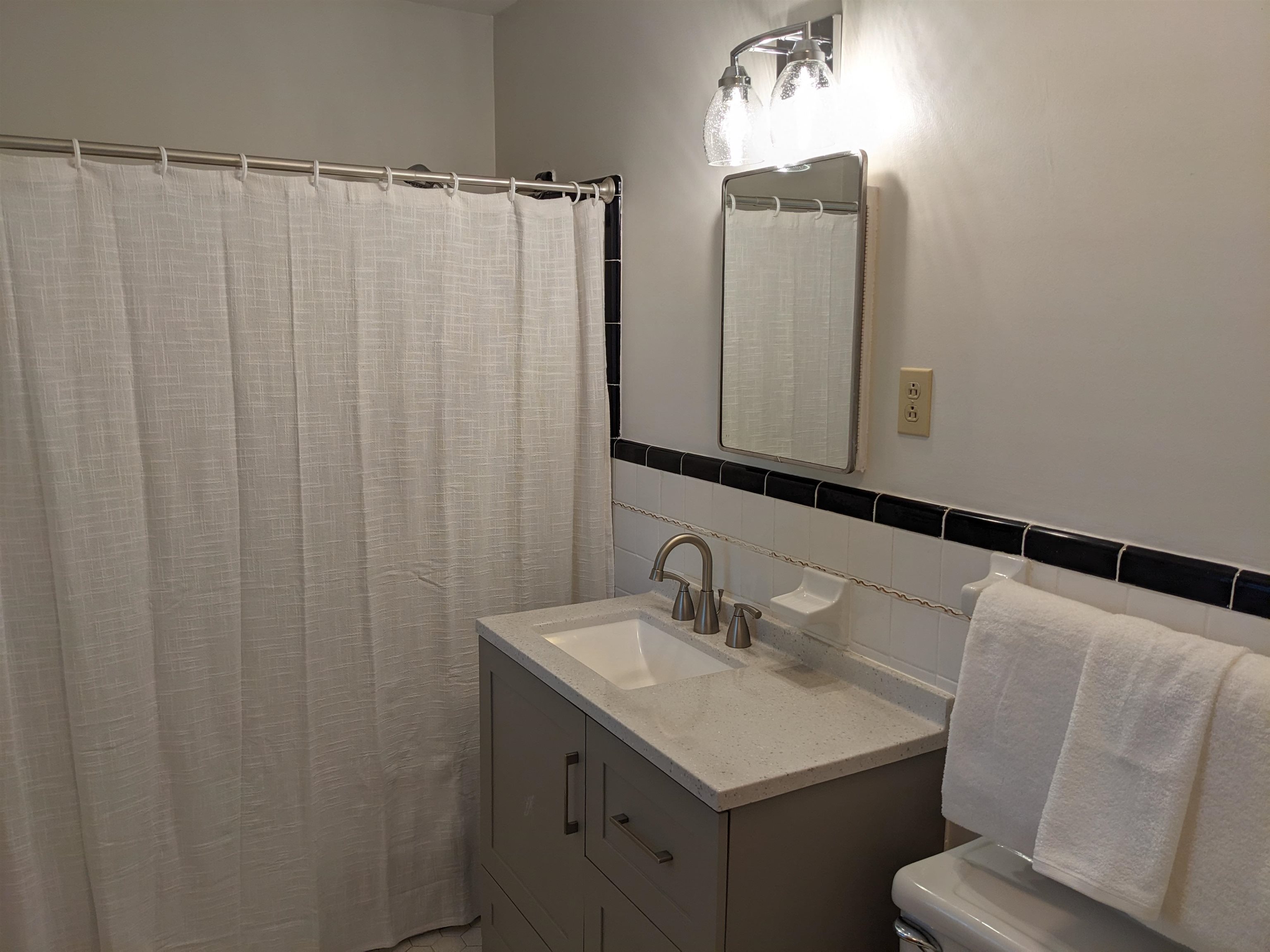 4696 Kaye Road Memphis, TN 38117 - Photo 27 of 39 a bathroom with a sink a mirror and a shower curtain