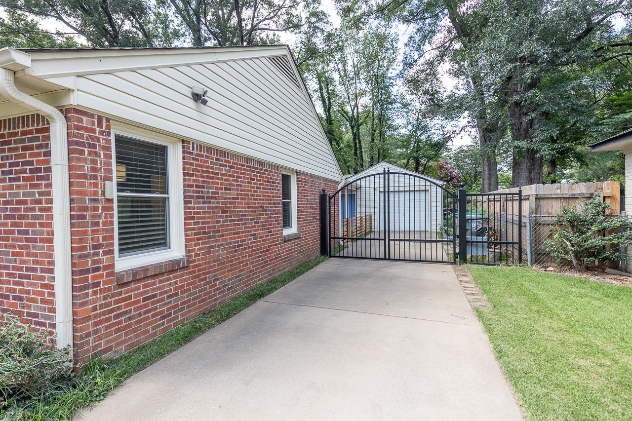 4696 Kaye Road Memphis, TN 38117 - Photo 3 of 39 a front view of a house with a garden and trees