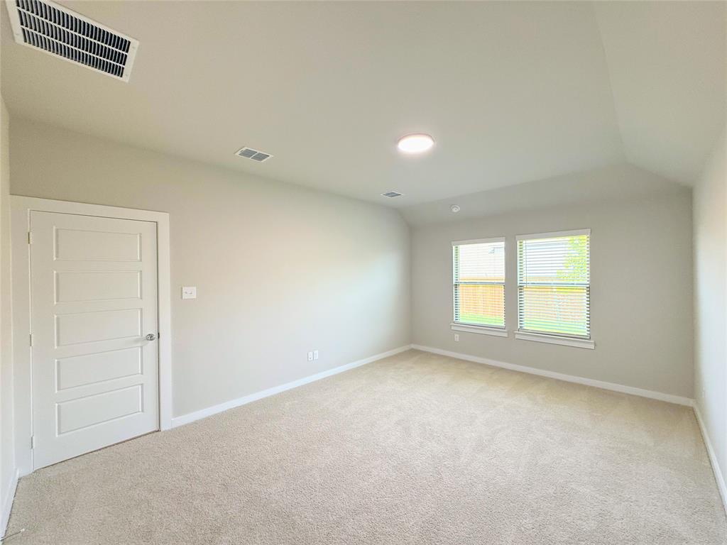 1909 Sandpiper Way Princeton, TX 75407 - Photo 11 of 35 Spare room with light carpet and vaulted ceiling