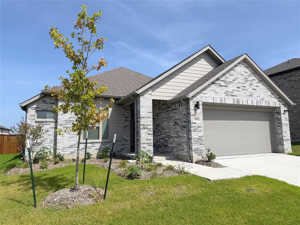 1909 Sandpiper Way Princeton, TX 75407 - Photo 2 of 35 View of front of home with a front lawn, roof with shingles, driveway, brick siding, and an attached garage