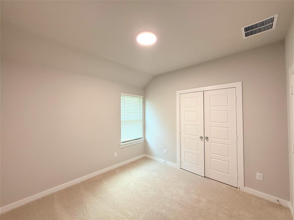 1909 Sandpiper Way Princeton, TX 75407 - Photo 23 of 35 Unfurnished bedroom featuring lofted ceiling, light colored carpet, and a closet