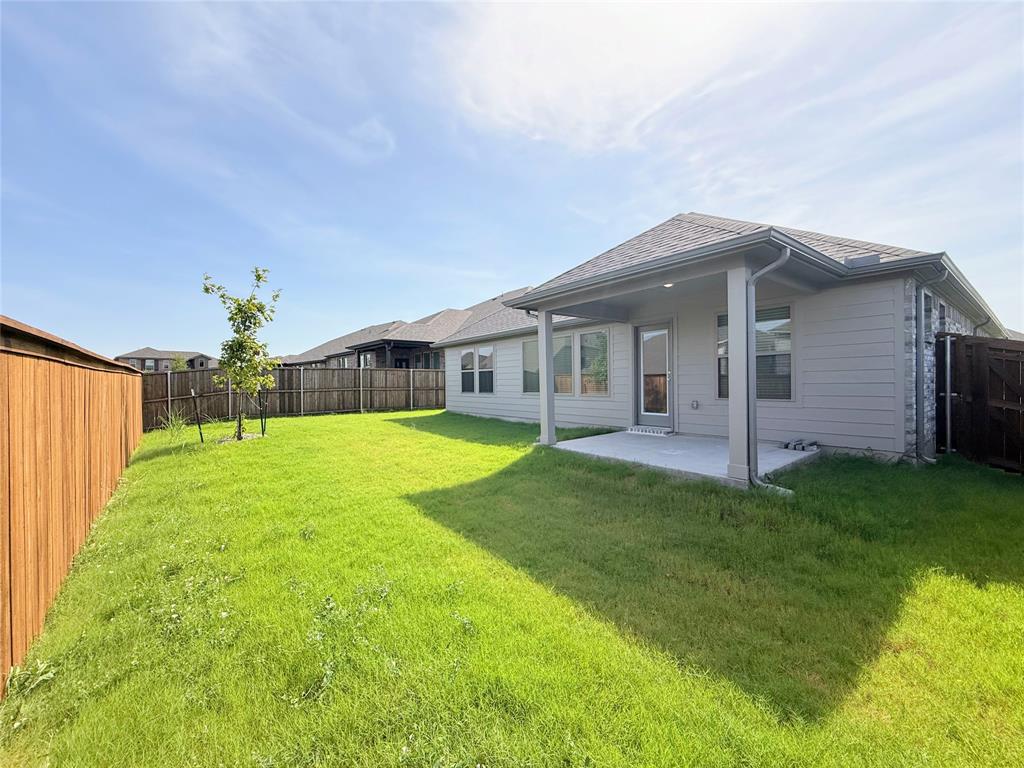 1909 Sandpiper Way Princeton, TX 75407 - Photo 27 of 35 Back of house with a fenced backyard, a patio area, and roof with shingles