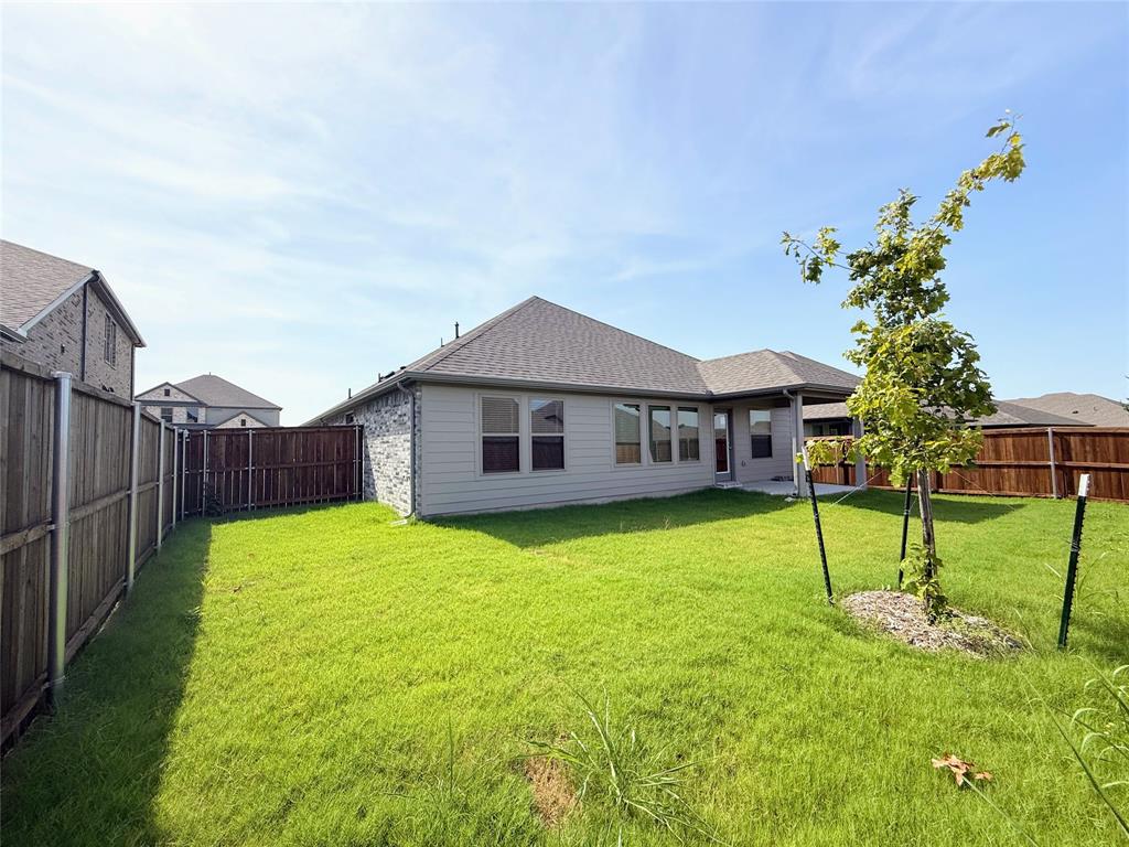 1909 Sandpiper Way Princeton, TX 75407 - Photo 30 of 35 Rear view of house with a fenced backyard, a patio, and roof with shingles